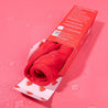Rolled up love red MakeUp Eraser inside of packaging.