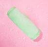 Rolled up Neon Green MakeUp Eraser surrounded by water.