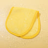 Folded Mellow Yellow MakeUp Eraser cloth laying on water.