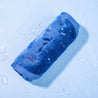 Rolled up Royal Navy MakeUp Eraser surrounded by waterdrops.