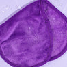 Folded Queen Purple MakeUp Eraser surrounded by waterdrops..