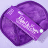 Queen Purple MakeUp Eraser packaging on top of folded Queen Purple MakeUp Eraser cloth surrounded by waterdrops.