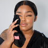 Woman holding Chic Black MakeUp Eraser up to her face.