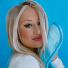 Woman smiling and holding up Chill Blue MakeUp Eraser to her face.