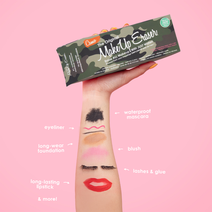 Hand holding Camo Print MakeUp Eraser packaging. There is writing on the arm that calls out the various makeup that MakeUp Eraser can remove. 