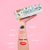 Hand holding Wildflowers Print MakeUp Eraser packaging. There is writing on the arm that calls out the various makeup that MakeUp Eraser can remove.