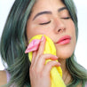 Woman holding up Mellow Yellow MakeUp Eraser to her face.
