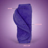 Rolled up Queen Purple MakeUp Eraser with both sides exposed. The short fiber side is labeled as erase, and the long fiber side is labeled as exfoliate.
