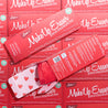 Rolled up love red MakeUp Eraser inside of packaging next to another Lover red MakeUp Eraser box.