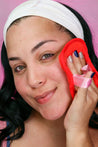 Woman holding Road Less Traveled 7-Day Set MakeUp Eraser cloth to face.